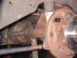 Axle positioned under car, upper  and lower arm connections visible