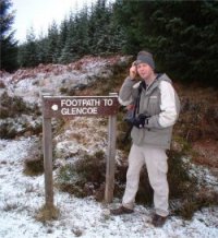 Chris with GPS in front of signpost