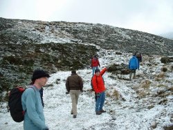 Group walking up snowy Schiehallion