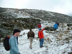 Group walking up snowy Schiehallion