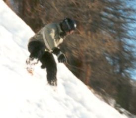 Dan snowboarding down a steep slope