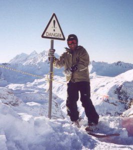 Dan resting against a danger sign