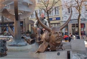 Chris sitting on statue at fountain